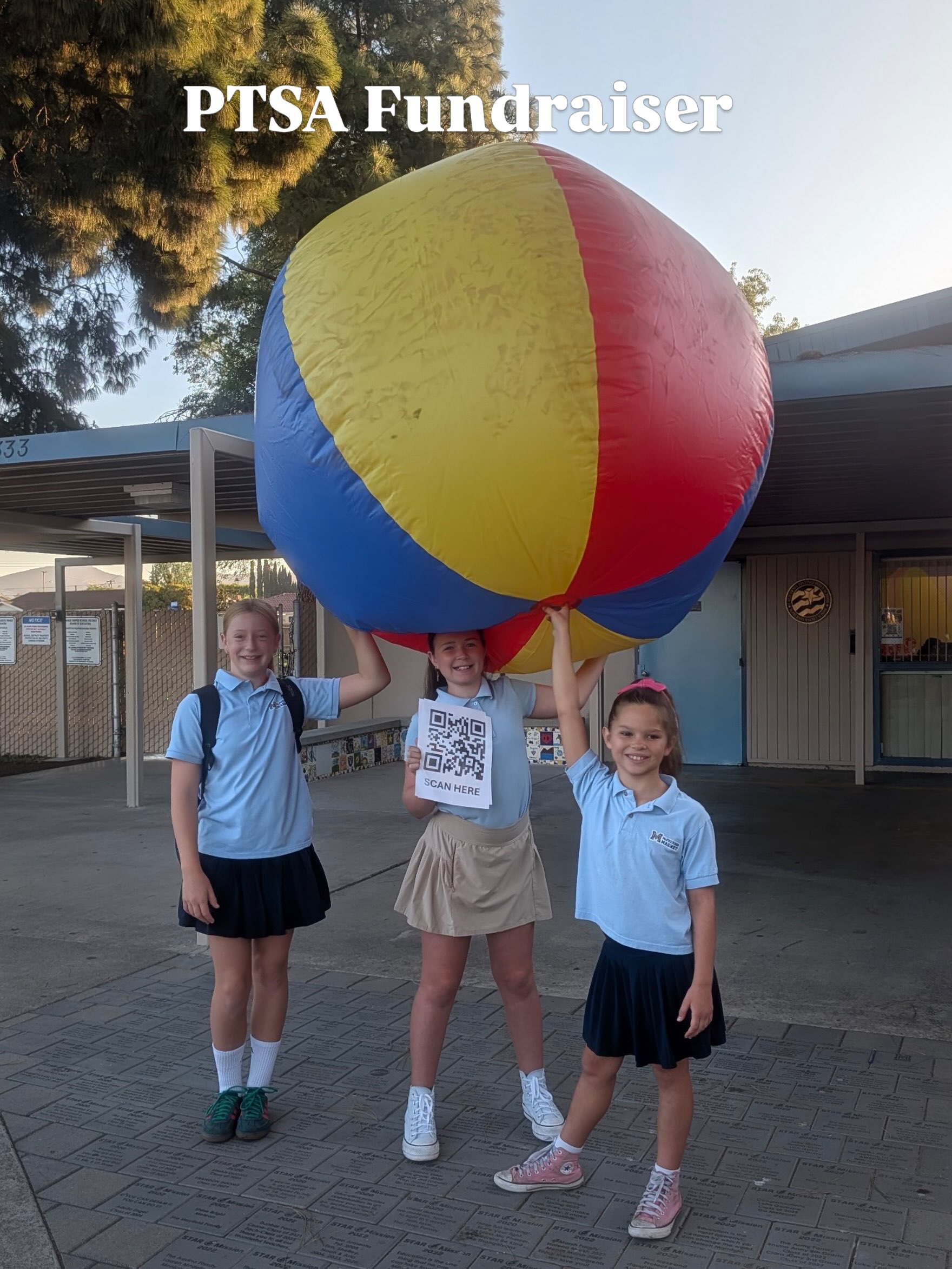 Three McPherson students holding the giant signed beach ball for the PTSA fall fundraiser
