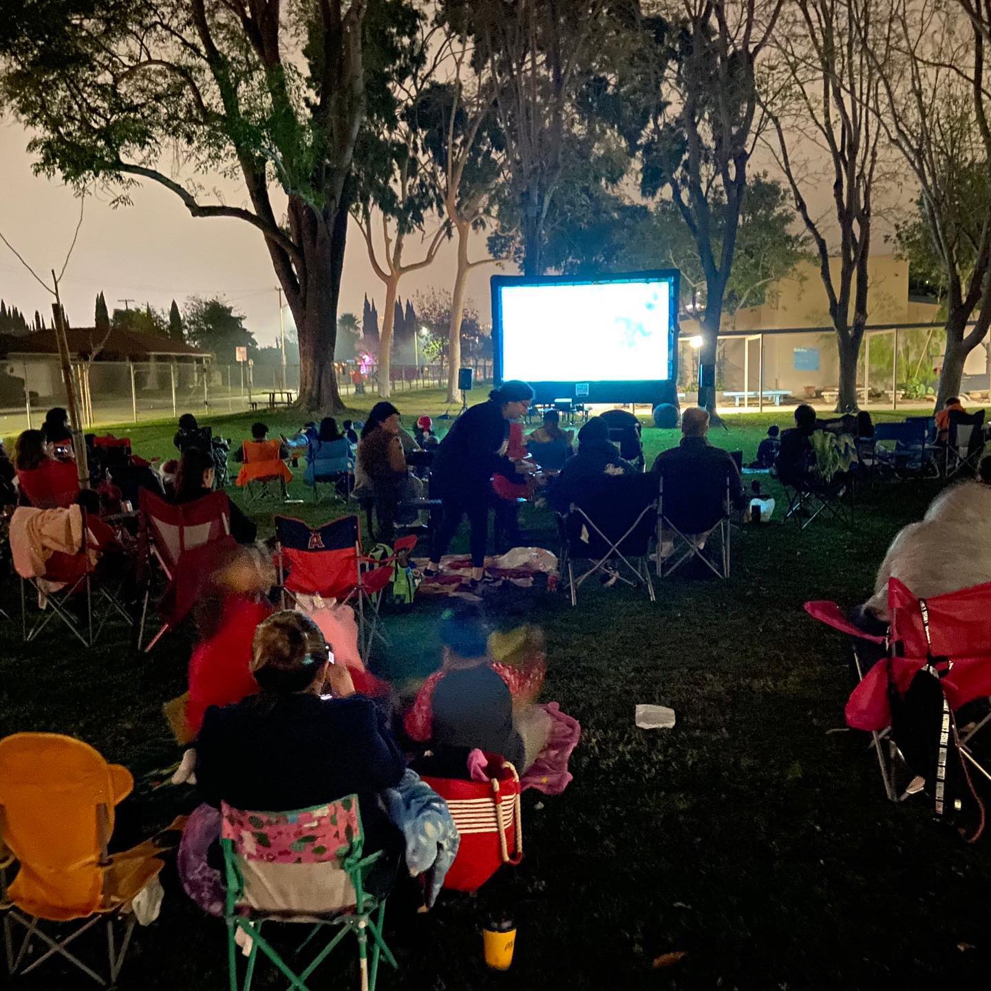 McPherson families gathered in lawn chairs for an outdoor PTSA movie night on campus